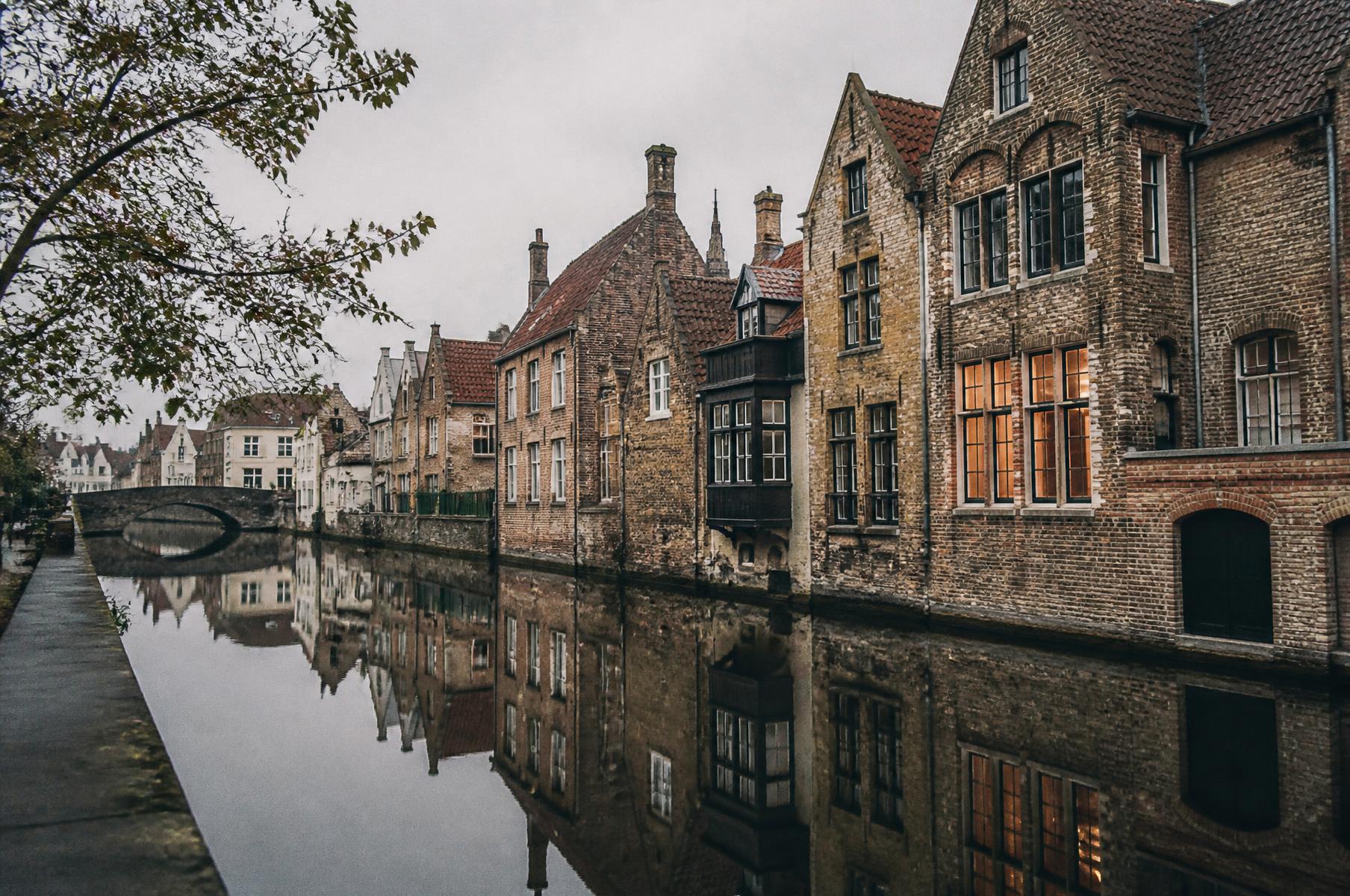 Casas históricas refletidas em um canal de Bruges, roteiro personalizado na Bélgica